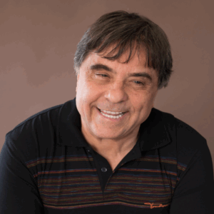 Geraldo é um homem branco, 50 mais, cabelos grisalhos. Veste pólo preta. Ao fundo, parede marrom