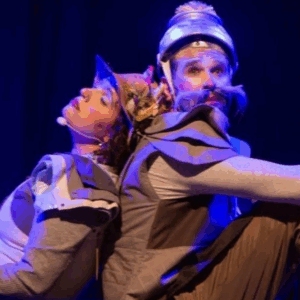 Grupo Casa de Lua. Uma mulher e um homem sentados de costas um para o outro. Vestem armaduras.